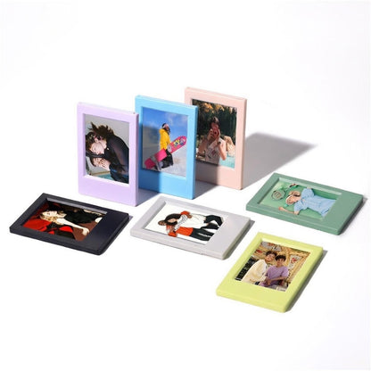 Set of colorful mini photo frames with variously styled photos inside on a white background